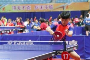 This picture shows a young table tennis player in action during a match.