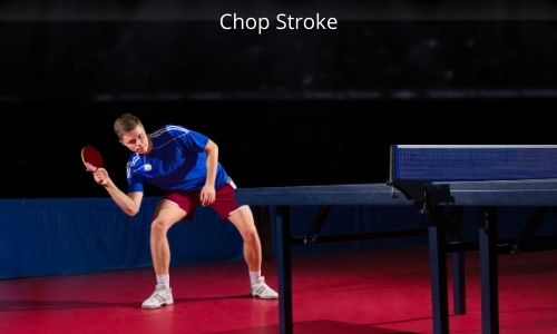 The player is executing a forehand chop shot in a table tennis game.
